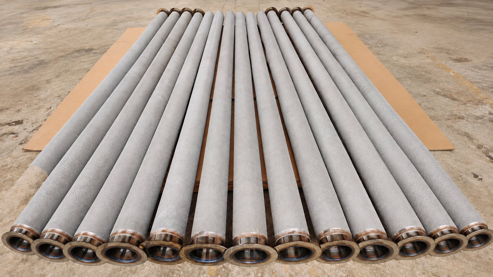 Sintered Metal Fiber Felt Filter Cartridges Long sintered metal fiber felt filter cartridges arranged on cardboard in the workshop