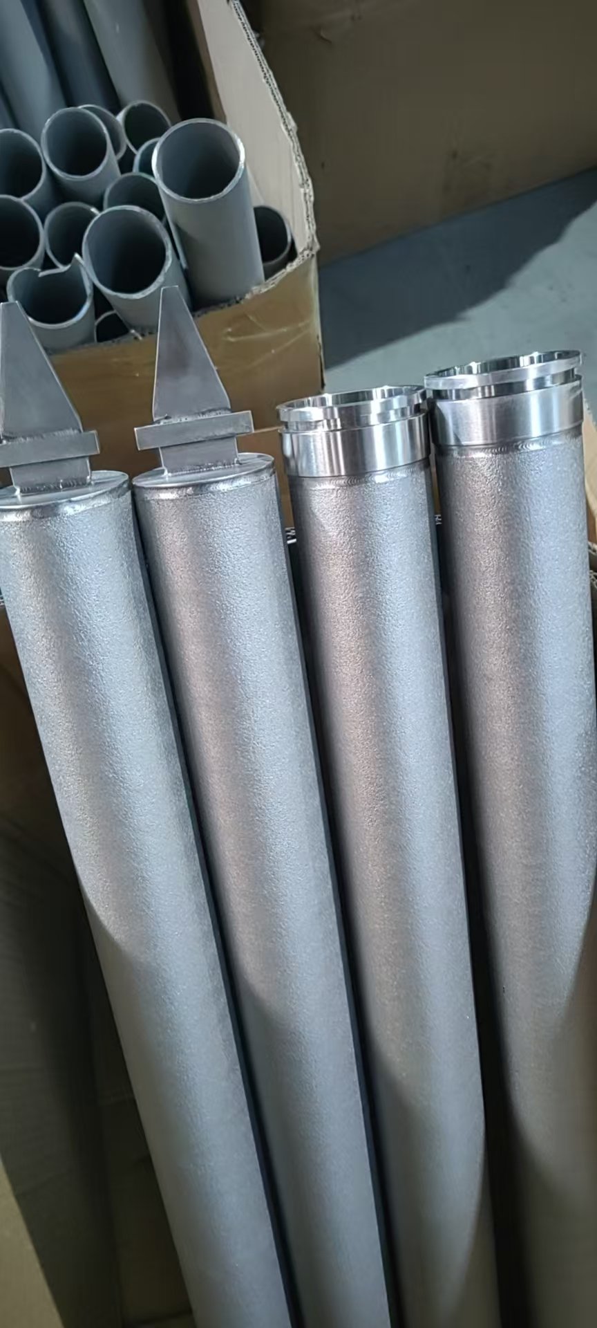 Powder-sintered porous metal cylinders with different connector ends