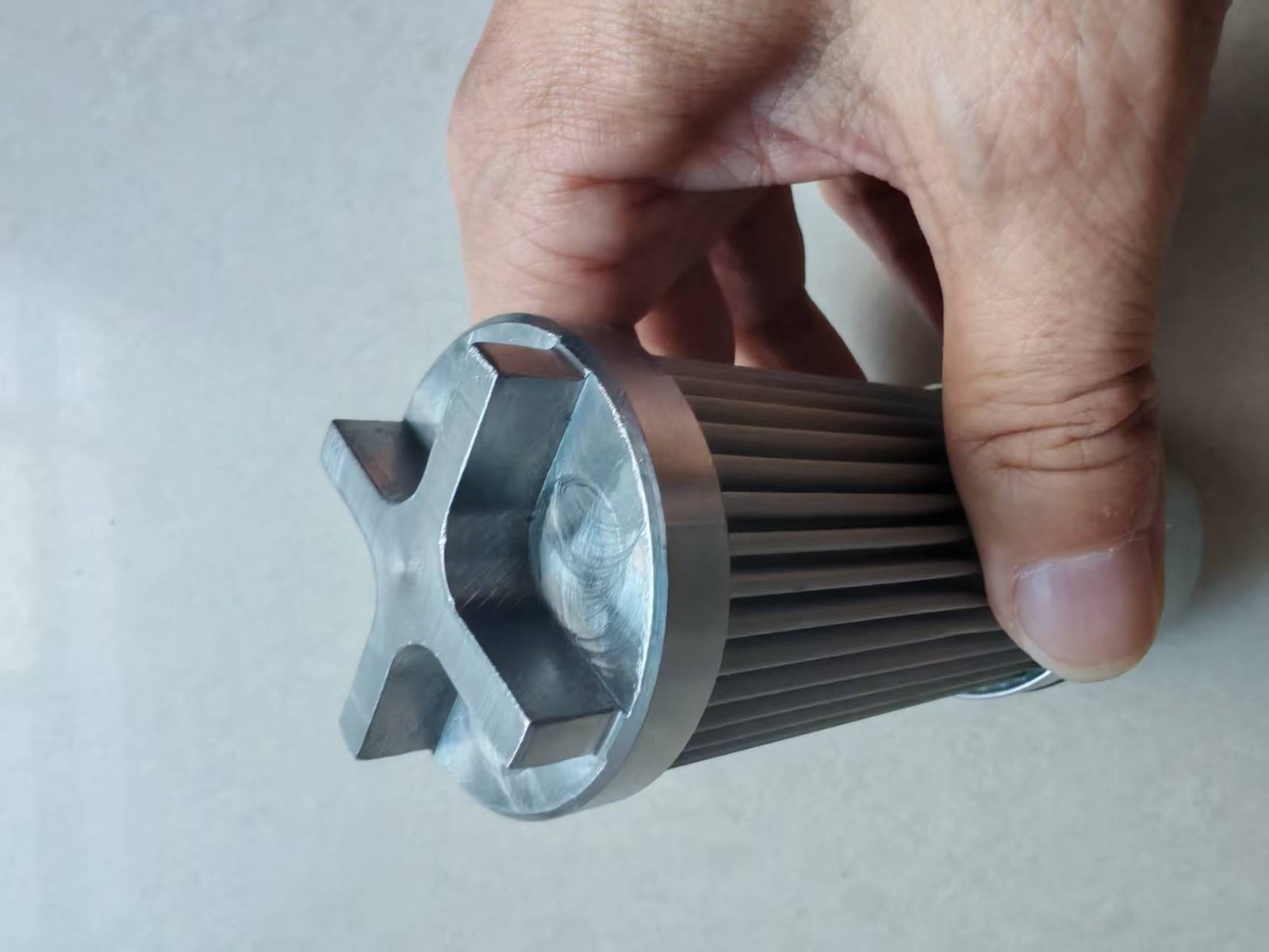 Close-up of a custom metal end fitting on a small pleated filter element
