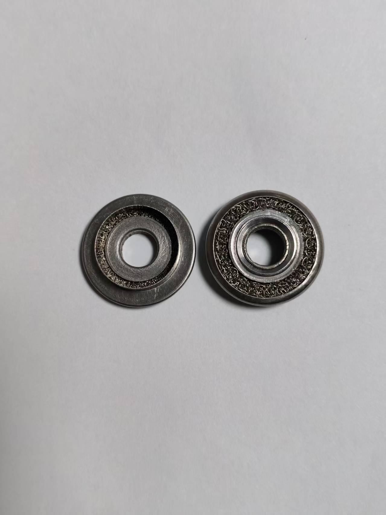 Metal and Knitted Wire Mesh Composite Components — Two Front Views Two metal components with knitted wire mesh filling, viewed from the front