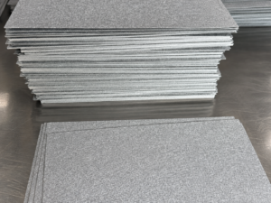 Stacked rectangular metal fiber felt sheets showing sheet surfaces and cut edges