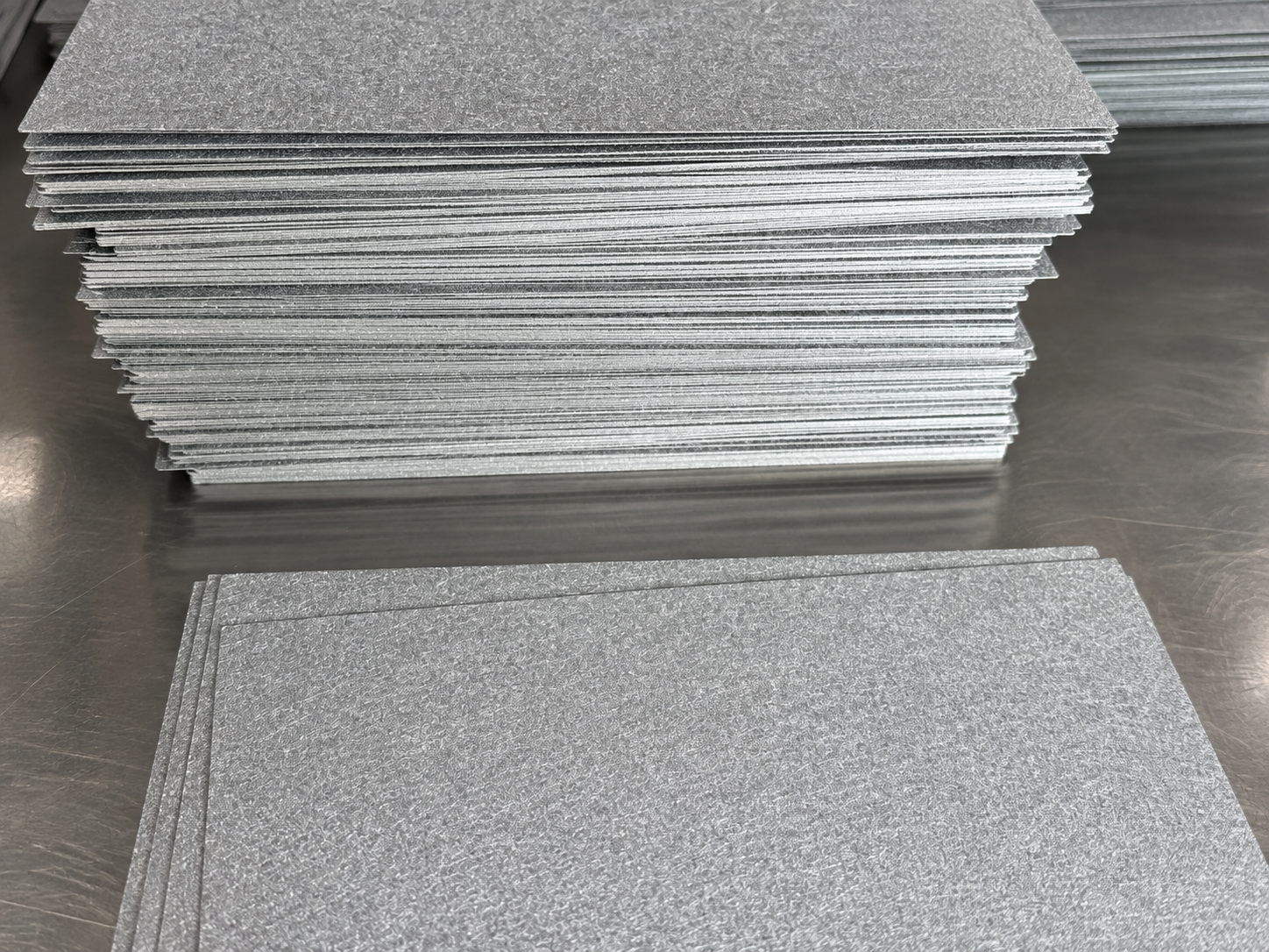 Sintered Titanium Felt Sheets for Batch Inspection Stacks of sintered titanium felt sheets on a workbench before batch inspection
