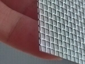 Close-up of a sintered wire mesh sheet edge and coarse woven surface