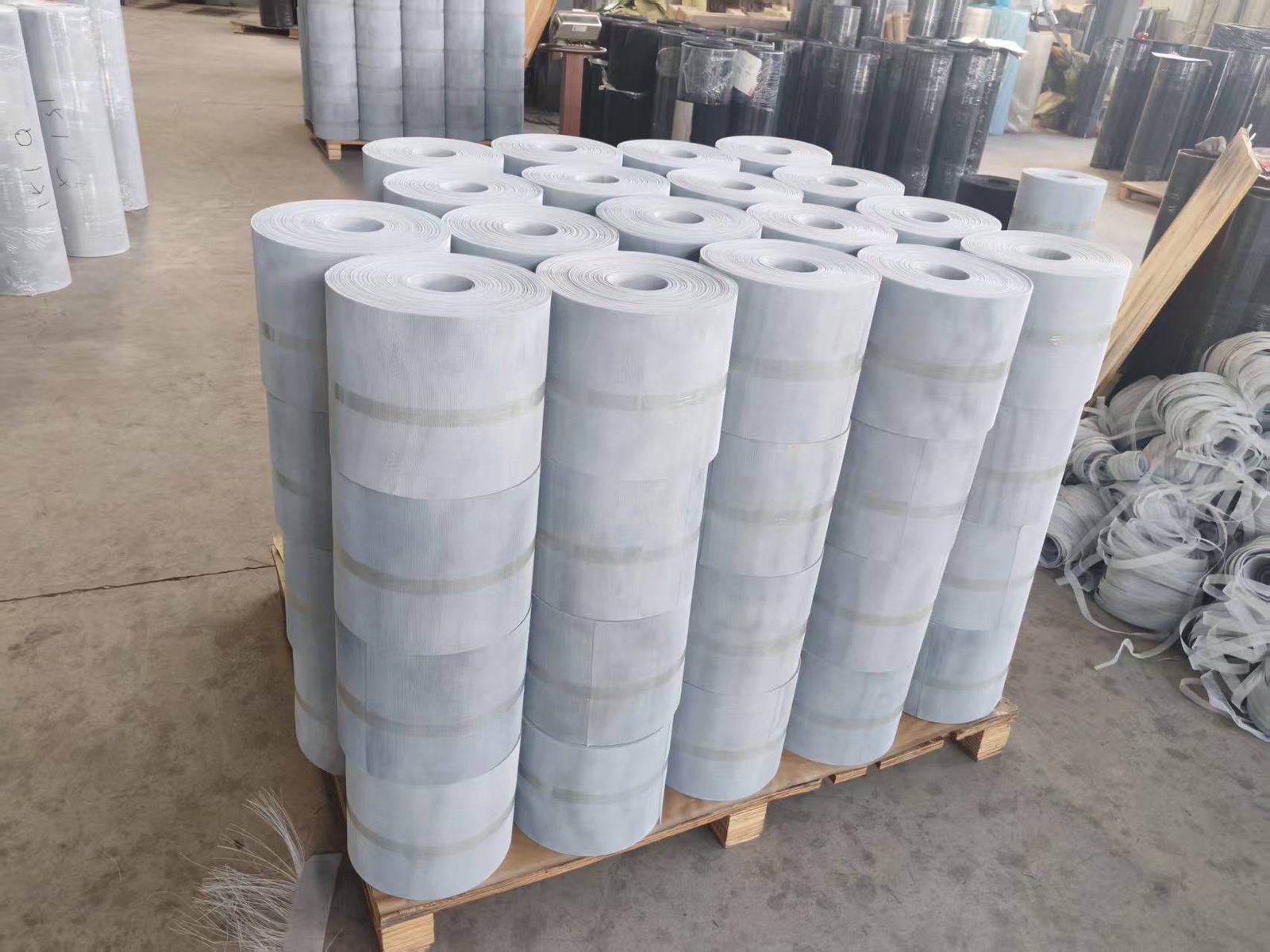 Light colored mesh rolls arranged on a wooden pallet