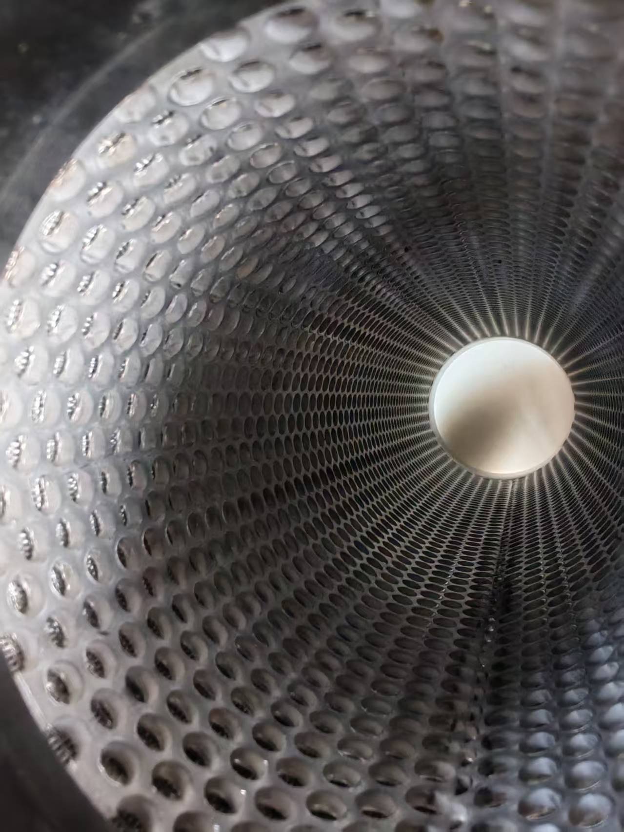 Inside a perforated filter support tube Interior view of a perforated tube showing the hole pattern