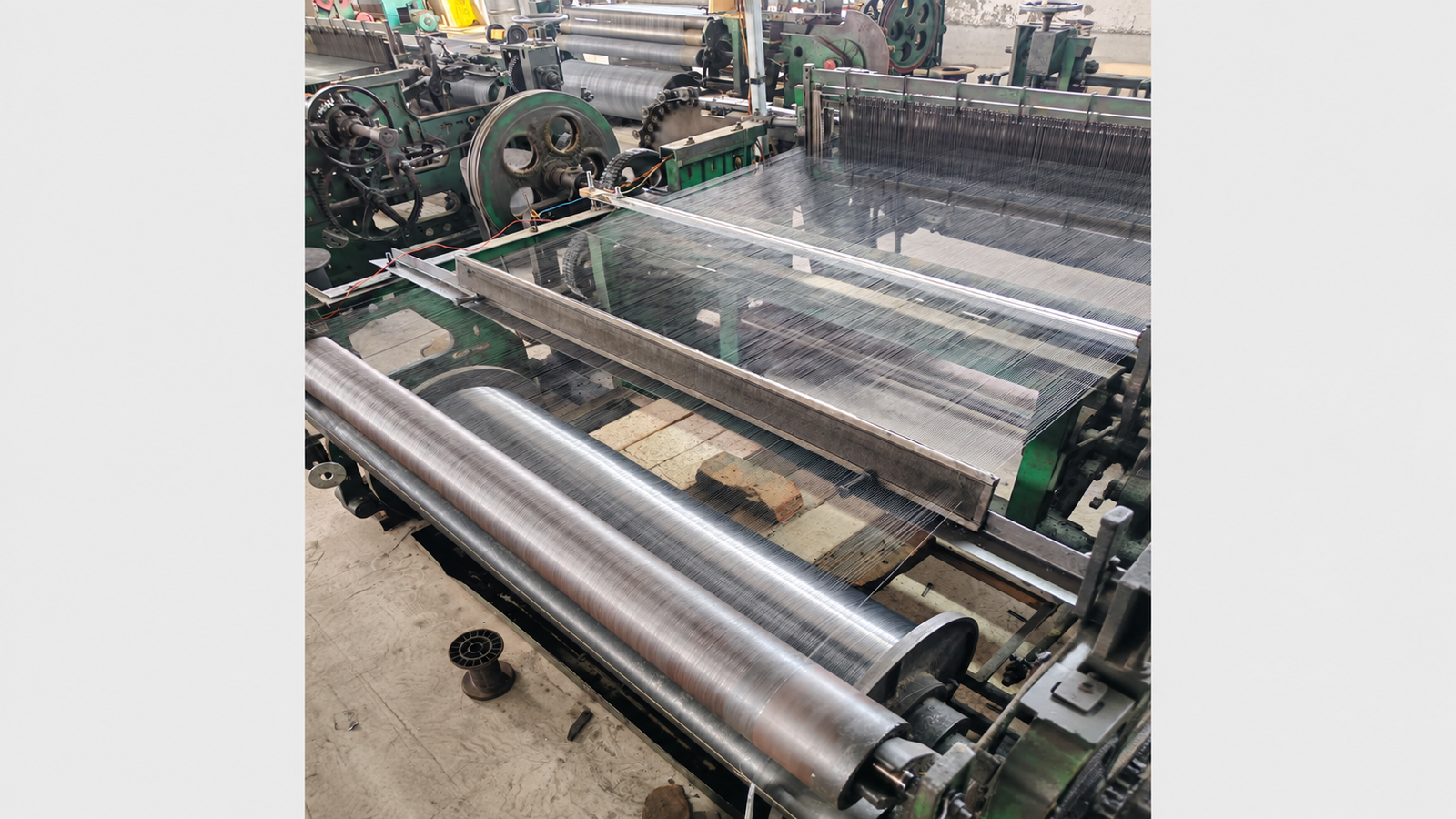 Plain woven wire mesh production on a weaving loom