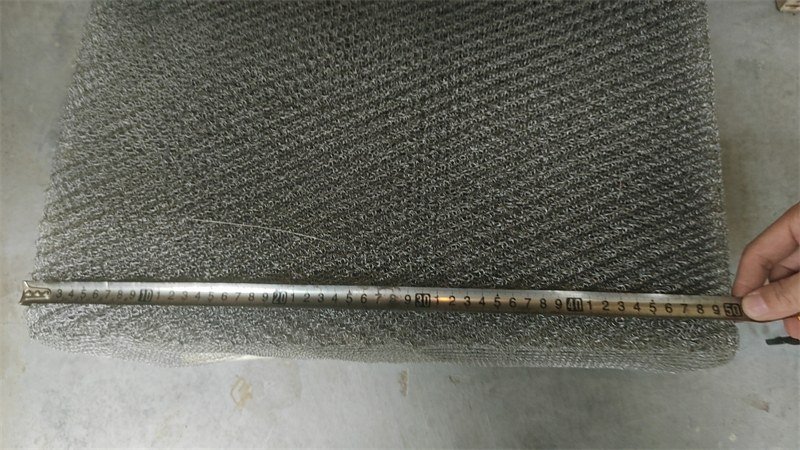 Wire mesh demister pad with a tape measure checking its overall dimension