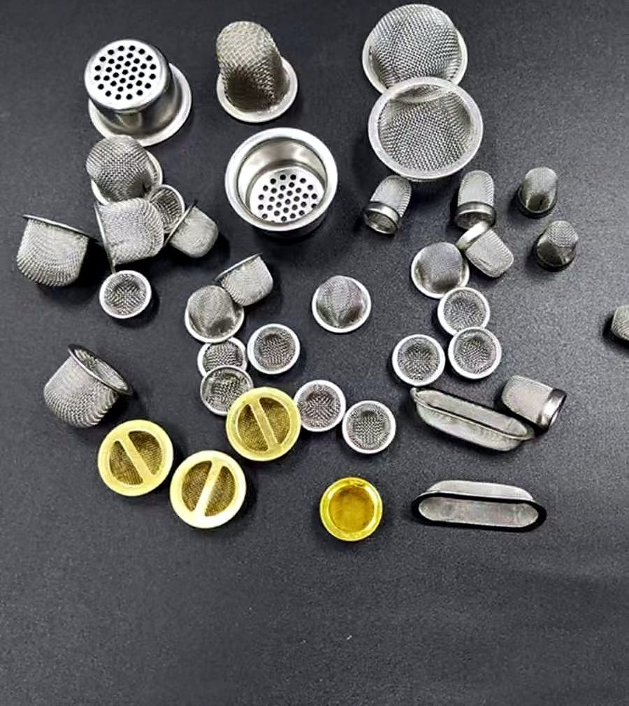 Small wire mesh filter caps, mesh discs and metal rim structures on a dark background