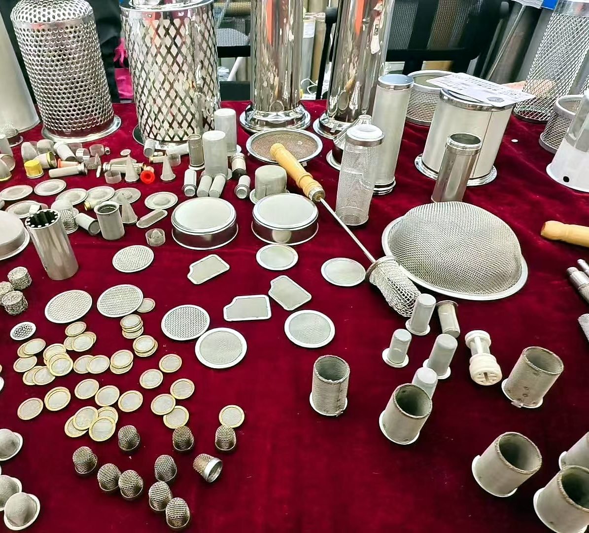 Cup-shaped wire mesh filter caps displayed with mesh discs and other filter components